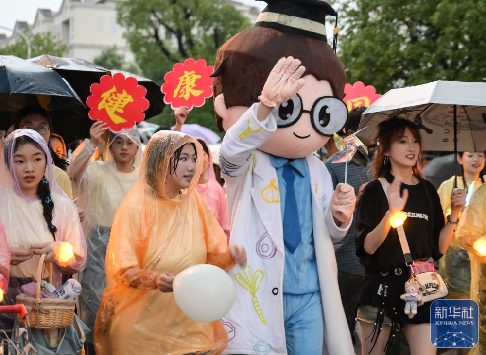 6月21日，必赢437官方网站学生在校园里冒雨巡游。2